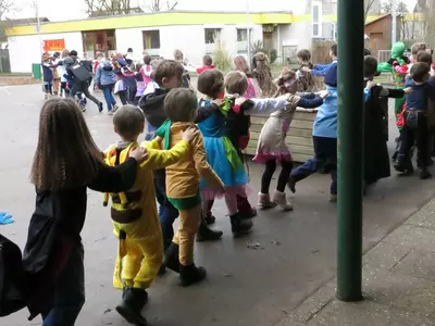 Die Kinder der Grundschule Höpfigheim tanzen auf dem Schulhof eine Faschingspolonaise.