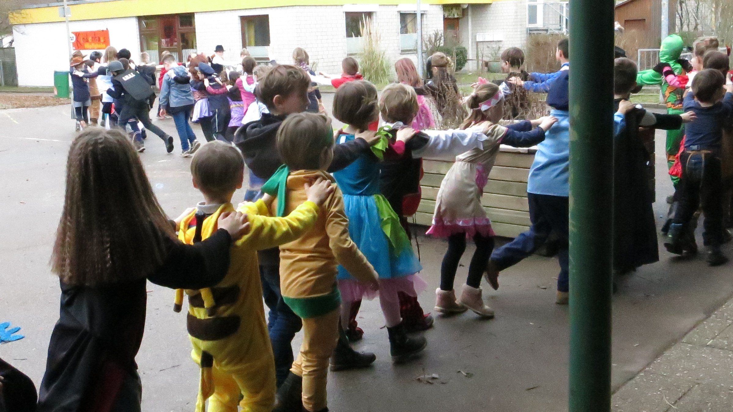Kinder der Grundschule Höpfigheim tanzen auf dem Schulhof eine Faschingspolonaise