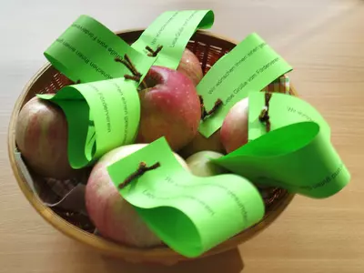 Korb mit Äpfeln mit grünen Blättern aus Papier mit guten Wünschen des Fördervereins